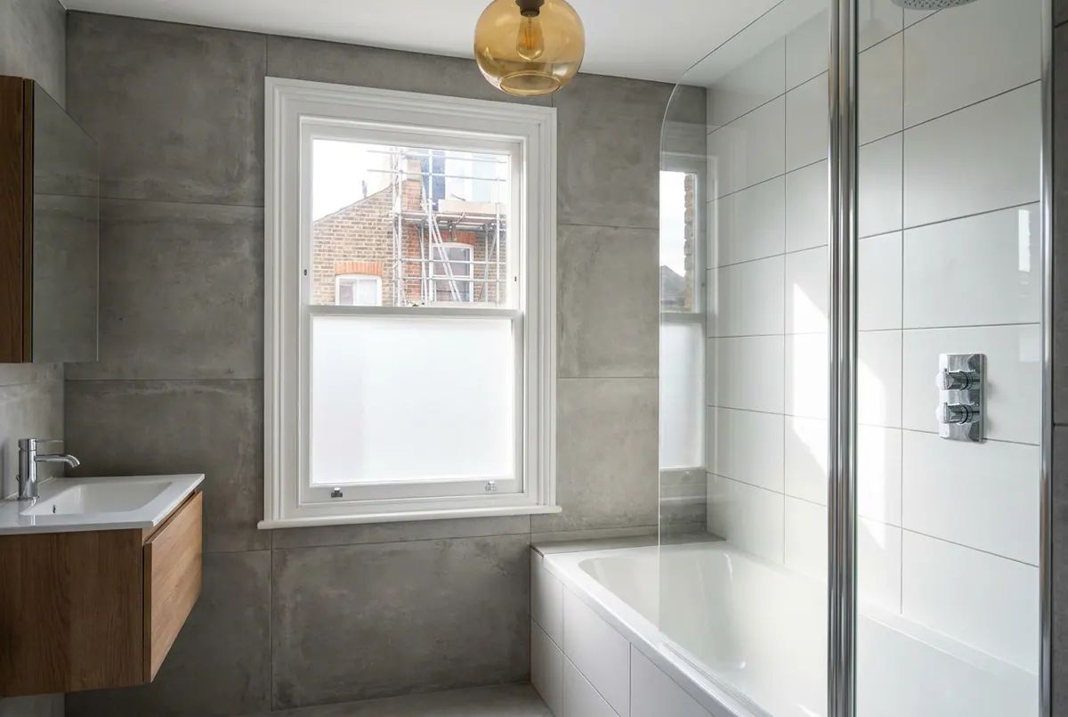 A newly completed family bathroom with a bath and shower